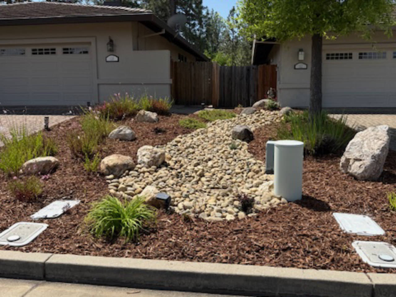 river rock landscape next to driveway